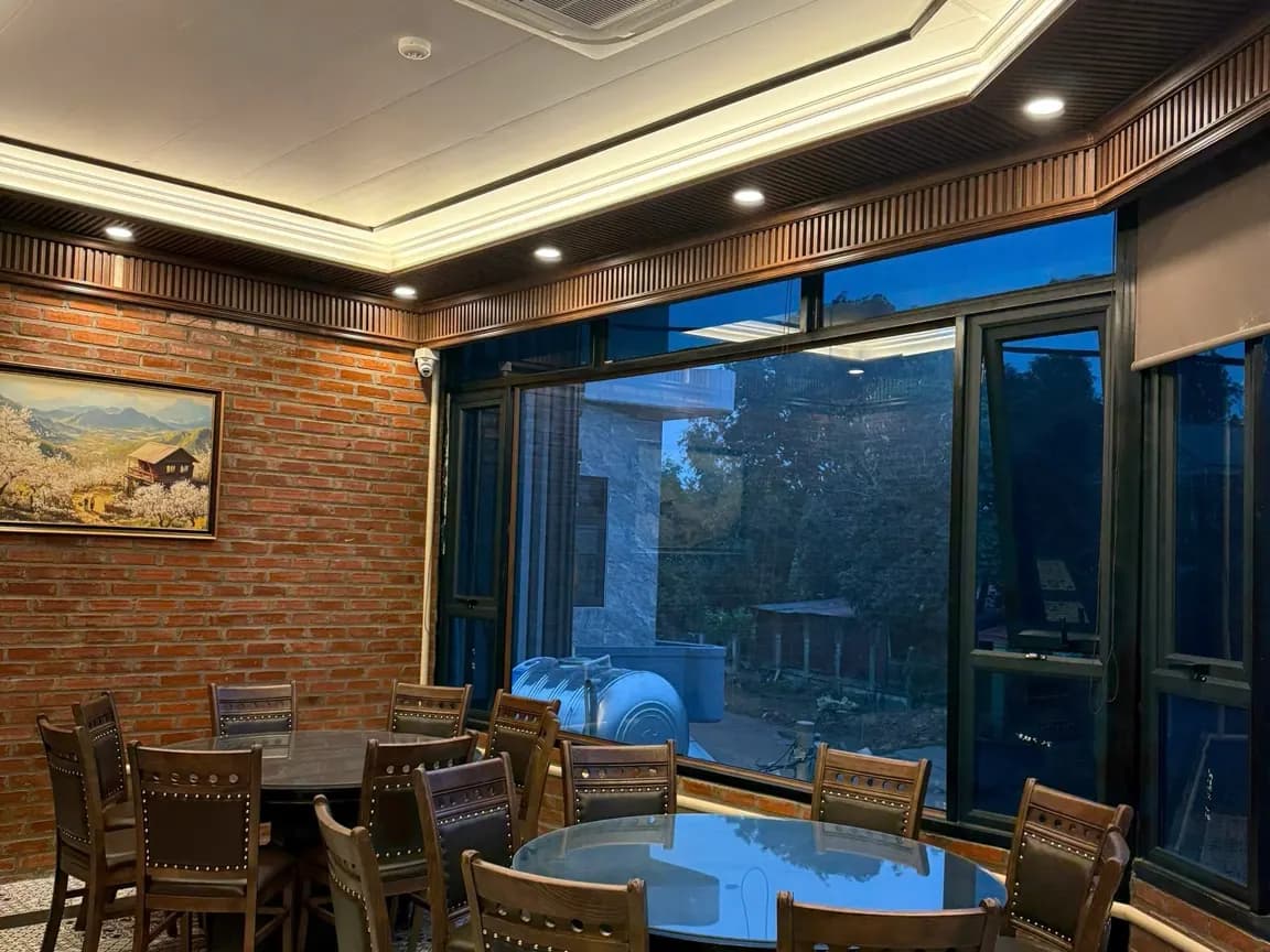 Khu bàn tròn đặt cạnh cửa kính lớn, phù hợp nhóm ngồi ghế
